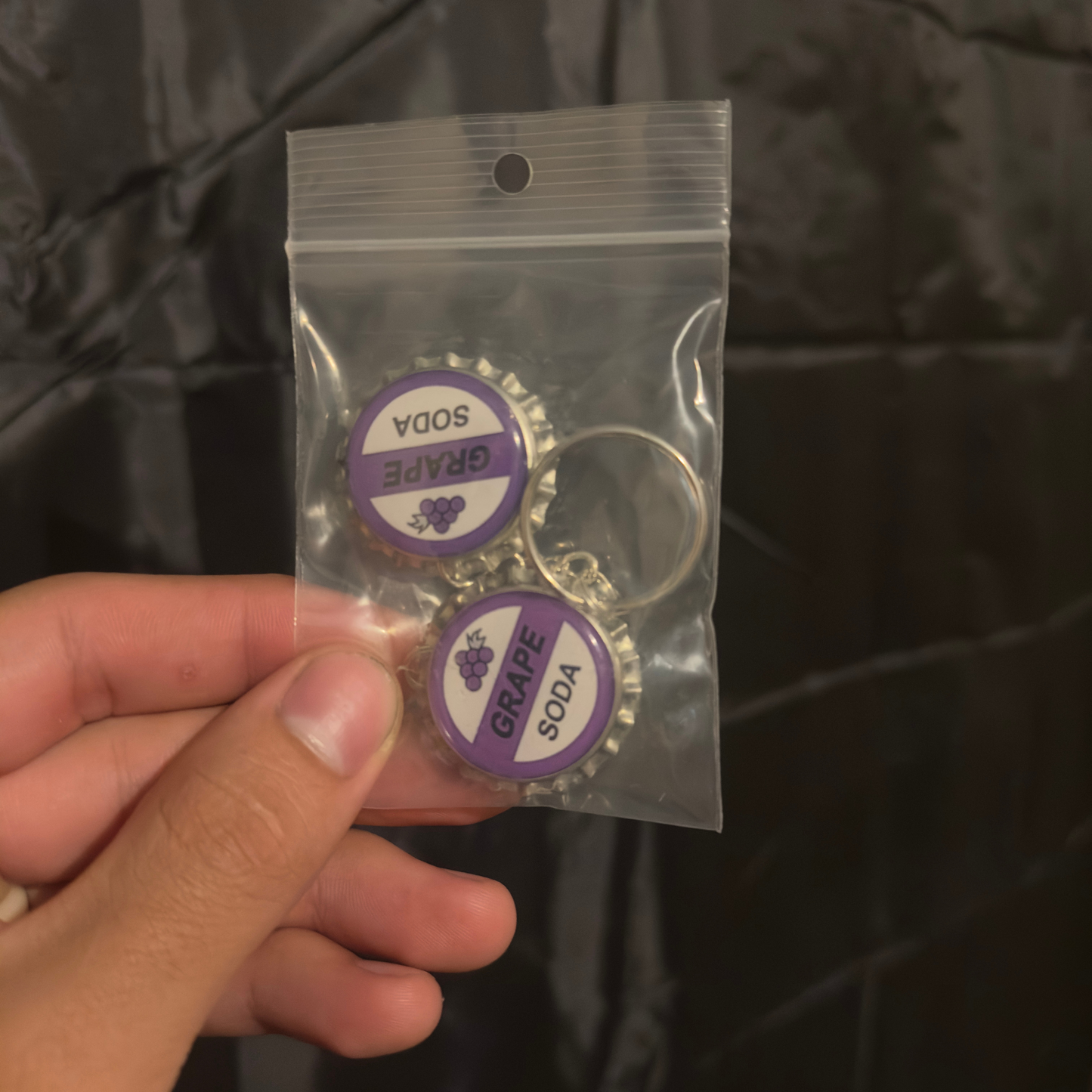 Llavero Ellie Badge Grape Soda – Réplica Botella de Uva (Set de 2)